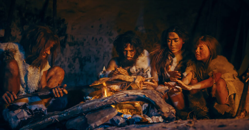 Neanderthalers rond een kampvuur eten aan het bereiden